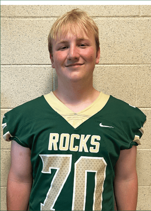 A young man wearing a white and black jersey with the number 14 on it. Description generated by AI