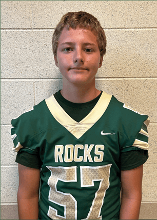 A young man wearing a white and black jersey with the number 14 on it. Description generated by AI