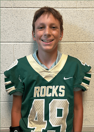 A young man wearing a white and black jersey with the number 14 on it. Description generated by AI