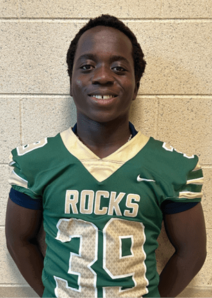 A young man wearing a white and black jersey with the number 14 on it. Description generated by AI