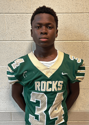 A young man wearing a white and black jersey with the number 14 on it. Description generated by AI