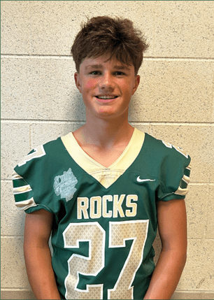 A young man wearing a white and black jersey with the number 14 on it. Description generated by AI