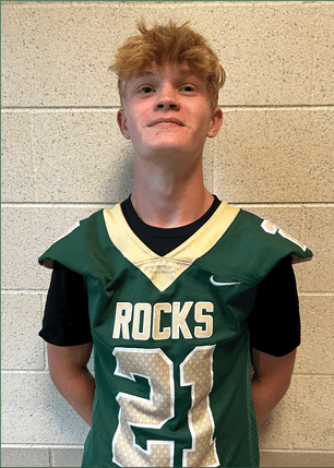 A young man wearing a white and black jersey with the number 14 on it. Description generated by AI