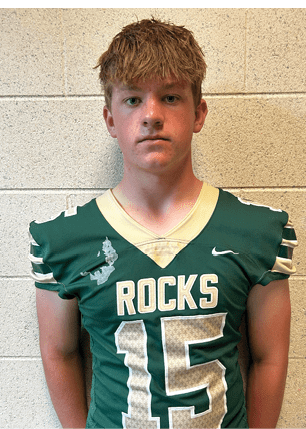 A young man wearing a white and black jersey with the number 14 on it. Description generated by AI