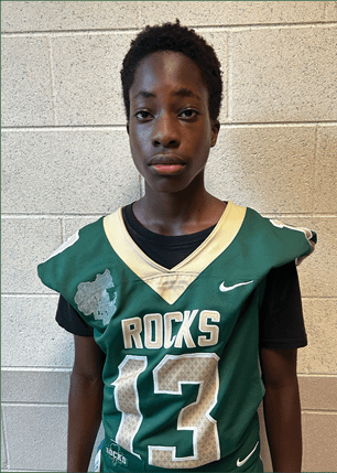 A young man wearing a white and black jersey with the number 14 on it. Description generated by AI