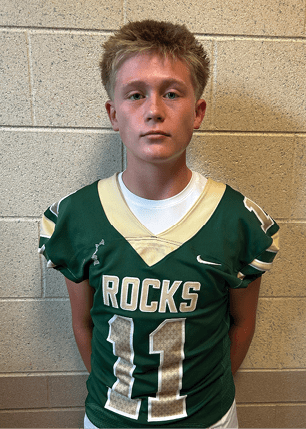 A young man wearing a white and black jersey with the number 14 on it. Description generated by AI