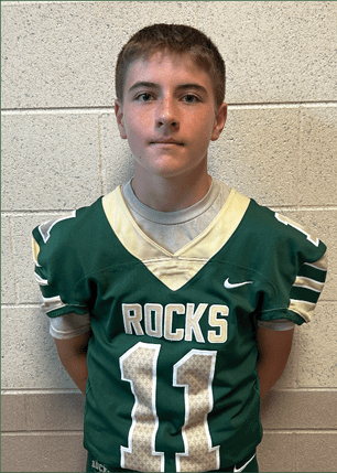 A young man wearing a white and black jersey with the number 14 on it. Description generated by AI