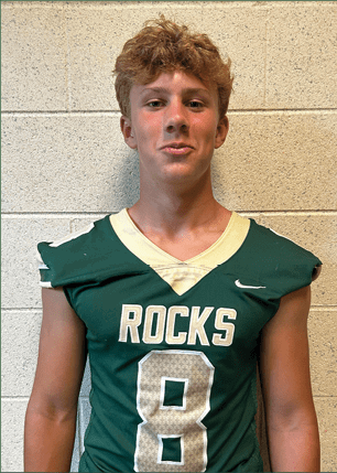 A young man wearing a white and black jersey with the number 14 on it. Description generated by AI