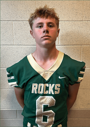 A young man wearing a white and black jersey with the number 14 on it. Description generated by AI