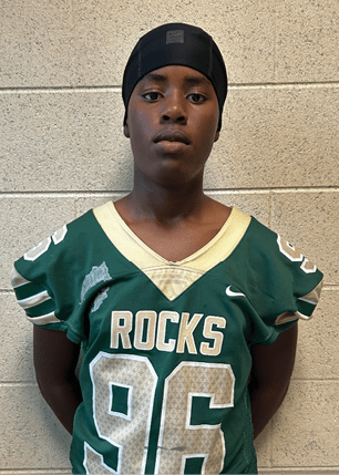 A young man wearing a white and black jersey with the number 14 on it. Description generated by AI