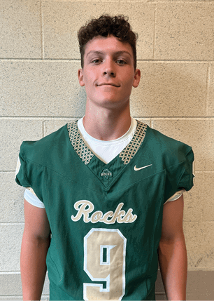 A young man wearing a white and black jersey with the number 14 on it. Description generated by AI