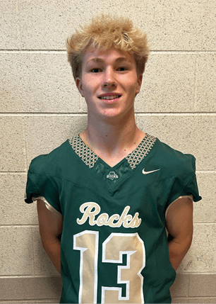 A young man wearing a white and black jersey with the number 14 on it. Description generated by AI