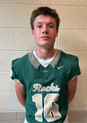 A young man wearing a white and black jersey with the number 14 on it. Description generated by AI