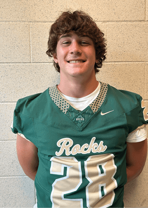 A young man wearing a white and black jersey with the number 14 on it. Description generated by AI