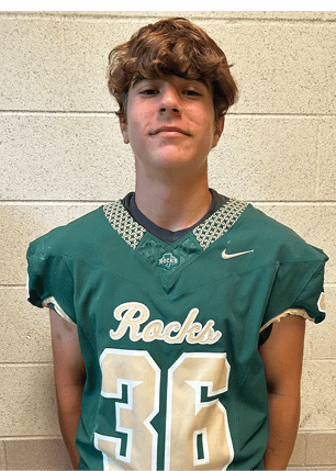 A young man wearing a white and black jersey with the number 14 on it. Description generated by AI