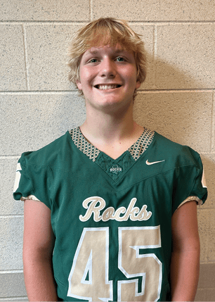 A young man wearing a white and black jersey with the number 14 on it. Description generated by AI