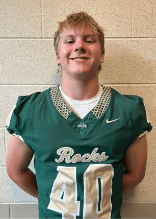 A young man wearing a white and black jersey with the number 14 on it. Description generated by AI