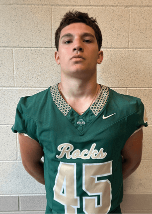 A young man wearing a white and black jersey with the number 14 on it. Description generated by AI