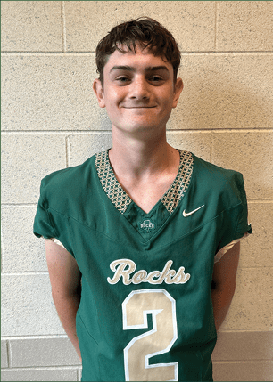 A young man wearing a white and black jersey with the number 14 on it. Description generated by AI