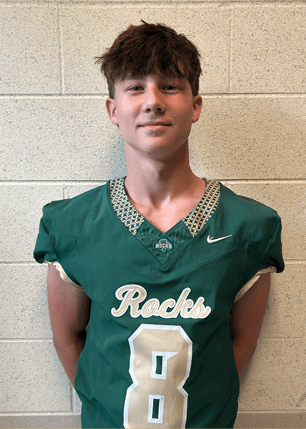 A young man wearing a white and black jersey with the number 14 on it. Description generated by AI