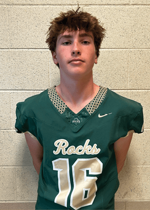 A young man wearing a white and black jersey with the number 14 on it. Description generated by AI