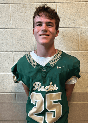 A young man wearing a white and black jersey with the number 14 on it. Description generated by AI