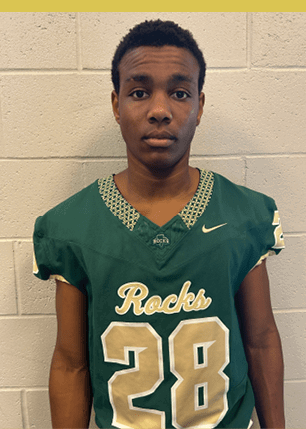 A young man wearing a white and black jersey with the number 14 on it. Description generated by AI