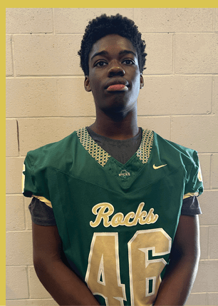 A young man wearing a white and black jersey with the number 14 on it. Description generated by AI