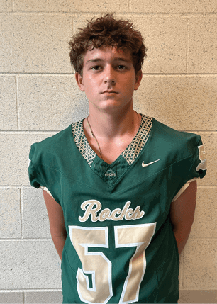 A young man wearing a white and black jersey with the number 14 on it. Description generated by AI