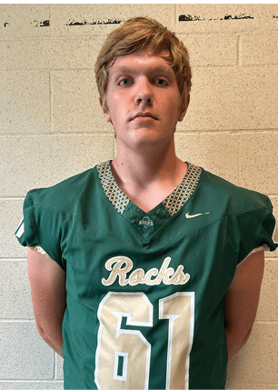 A young man wearing a white and black jersey with the number 14 on it. Description generated by AI