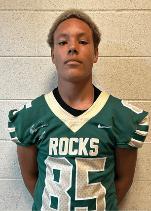 A young man wearing a white and black jersey with the number 14 on it. Description generated by AI