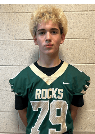 A young man wearing a white and black jersey with the number 14 on it. Description generated by AI