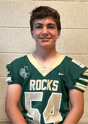 A young man wearing a white and black jersey with the number 14 on it. Description generated by AI