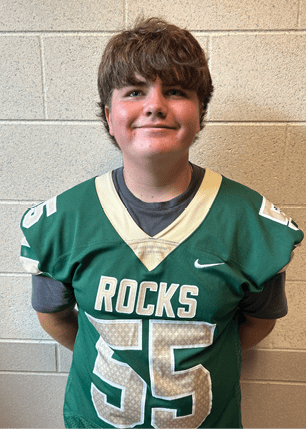A young man wearing a white and black jersey with the number 14 on it. Description generated by AI