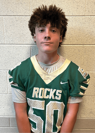 A young man wearing a white and black jersey with the number 14 on it. Description generated by AI