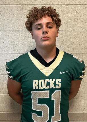 A young man wearing a white and black jersey with the number 14 on it. Description generated by AI