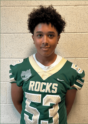 A young man wearing a white and black jersey with the number 14 on it. Description generated by AI