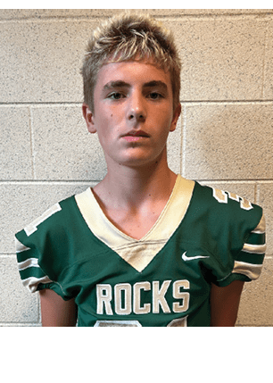 A young man wearing a white and black jersey with the number 14 on it. Description generated by AI
