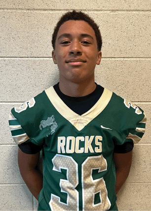 A young man wearing a white and black jersey with the number 14 on it. Description generated by AI