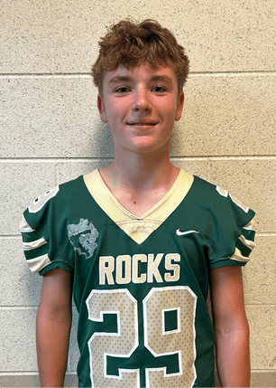 A young man wearing a white and black jersey with the number 14 on it. Description generated by AI