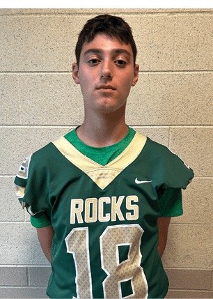 A young man wearing a white and black jersey with the number 14 on it. Description generated by AI