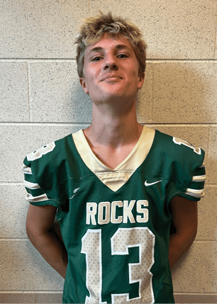 A young man wearing a white and black jersey with the number 14 on it. Description generated by AI