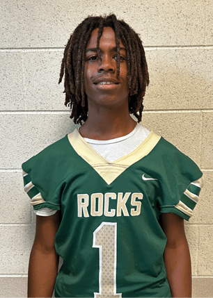 A young man wearing a white and black jersey with the number 14 on it. Description generated by AI