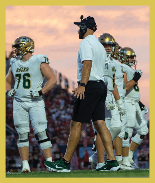 A football player in a white uniform is running with a football in his hand. AI generated content