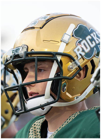 A football player wearing a blue and white uniform. Description generated by AI