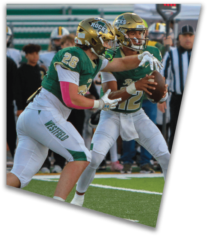 A person wearing a dark football uniform and helmet with “American Canyon" on the jersey is kneeling on one knee on a field at night. Description generated by AI