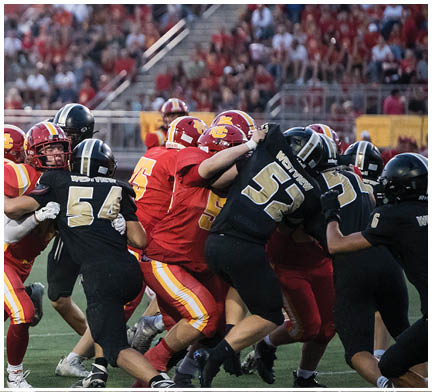 A football game is taking place with a group of men on the field. Description generated by AI