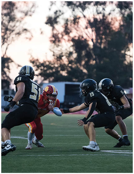 A football player wearing a blue and red jersey. Description generated by AI