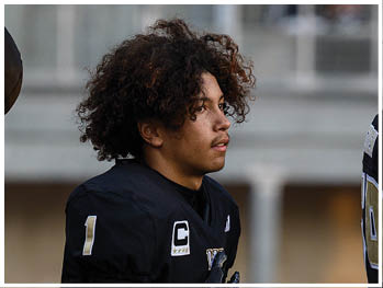 A football player running on the field. Description generated by AI