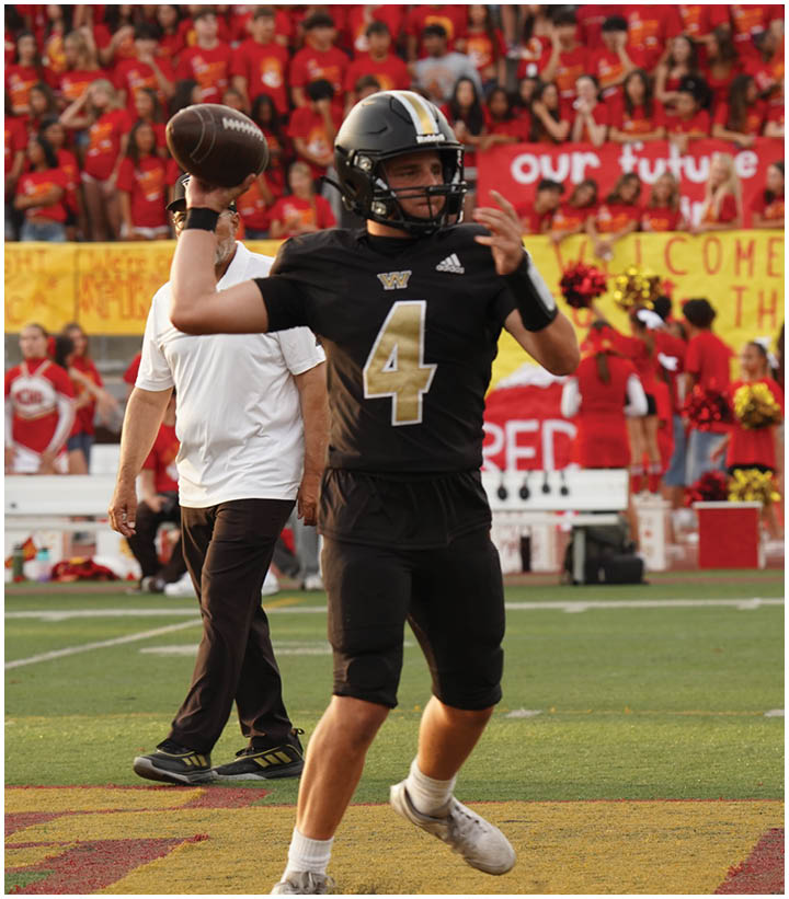 A group of football players wearing black and white uniforms. Description generated by AI